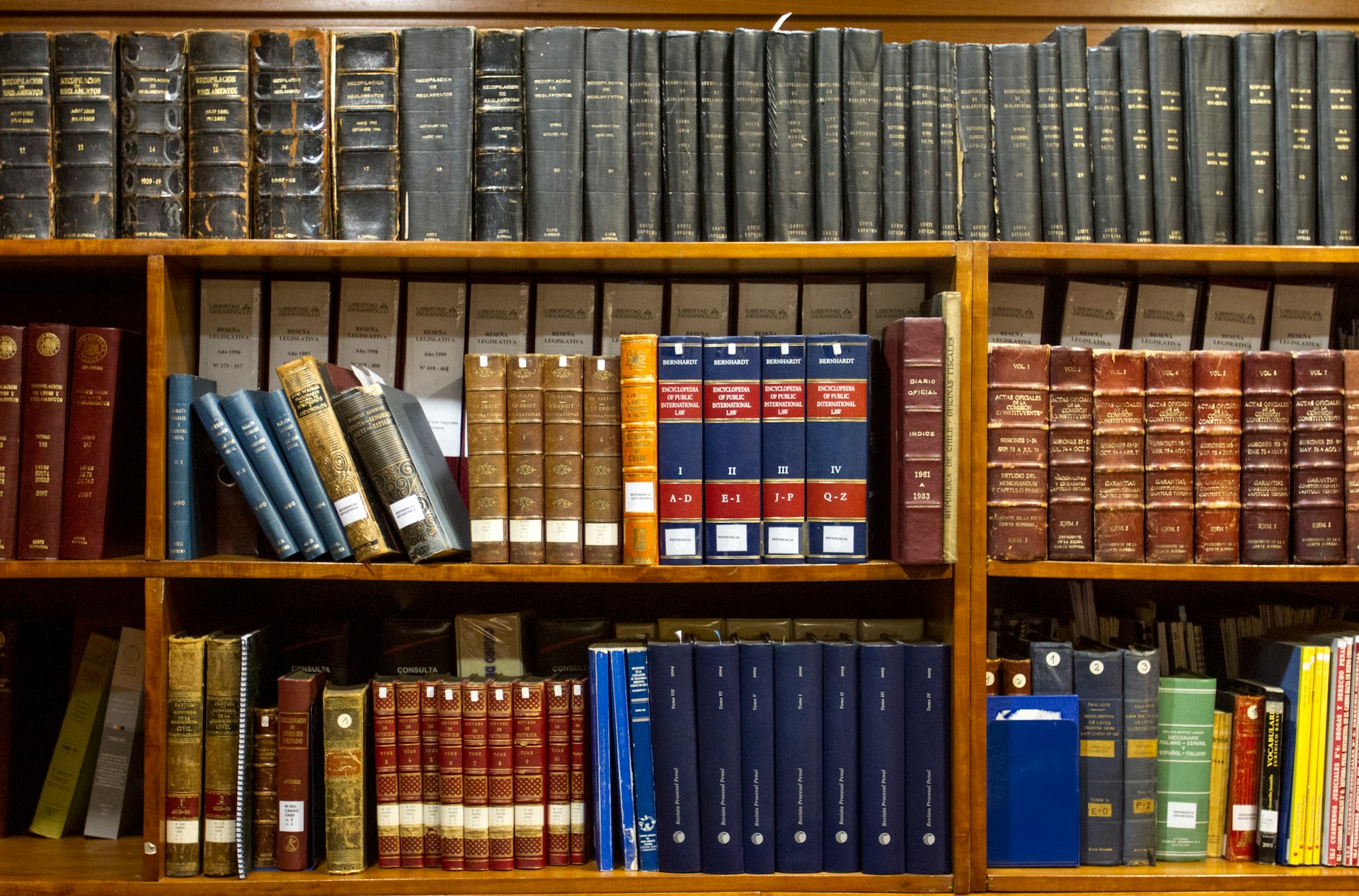 a bookshelf filled with lots of books on top of wooden shelves